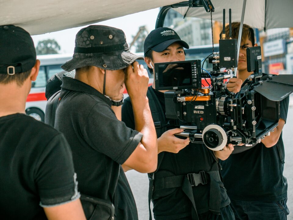 A group of filmmakers using professional camera equipment on an outdoor set.