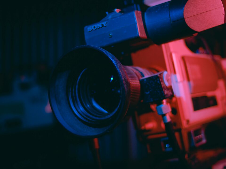 Artistic close-up of a vintage video camera lens in dramatic lighting.